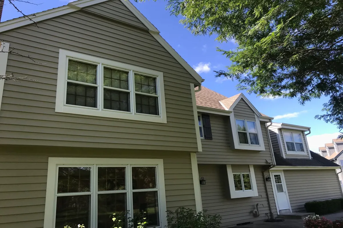 Large residential home with light green exterior paint